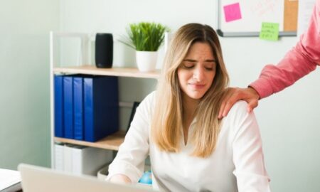 man touching woman coworker's shoulder