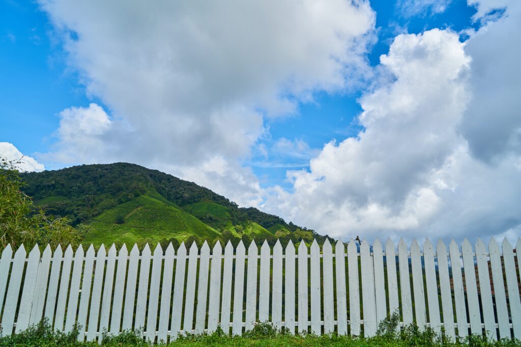 white fence with clouds and blue sky