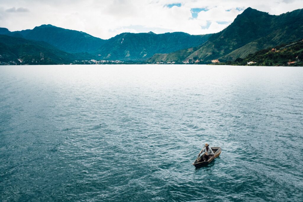 Lake with a fisherman, mountain range in Atitlán, Guatemala