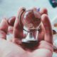 A man holds a glass globe in his hand, representing Elijah Norton’s global expansion efforts