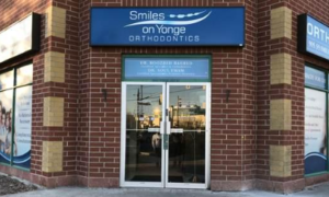 Exterior view of Smiles on Yonge Orthodontics in Richmond Hill, featuring the clinic's entrance and blue storefront signage.