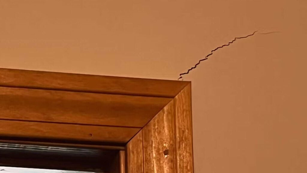 “Small crack forming above an interior door frame in a home.”
