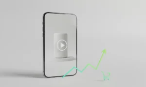 Smartphone showing a product video with a rising sales graph and shopping cart icon on a soft neutral background.