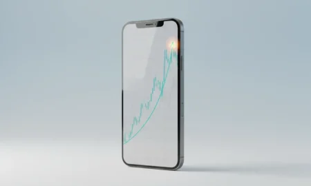 Sleek smartphone with an upward-trending financial chart on a soft gradient background, highlighting a breakout point.