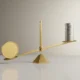 Minimal balance scale where one large gold coin outweighs a stack of small silver coins on a neutral background.