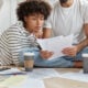Couple reviewing household bills and finances while exploring rent payment reporting services to build credit in 2026.