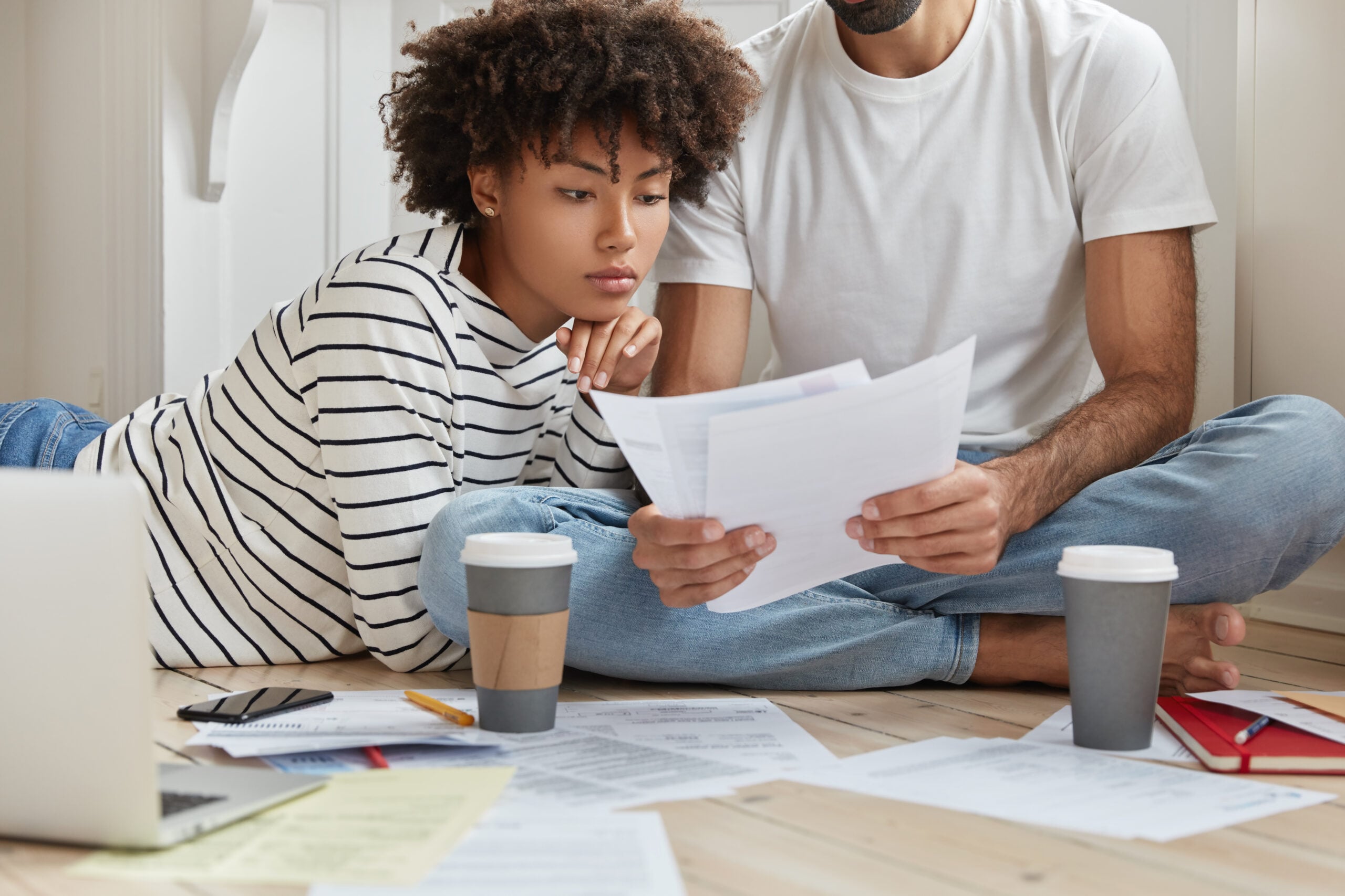 Couple reviewing household bills and finances while exploring rent payment reporting services to build credit in 2026.