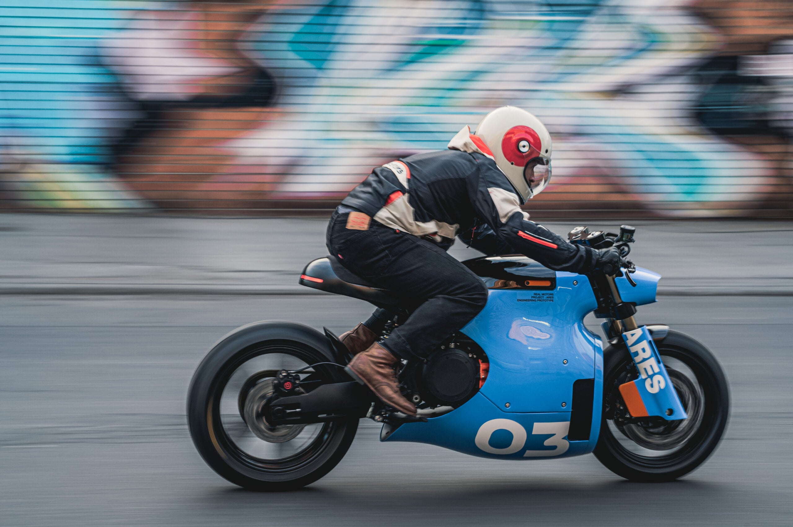 Project ARES electric café racer with a rider at the handlebars.