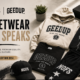 Folded NOFS black hoodie and Geedup grey tracksuit laid on a wooden floor beside sneakers.