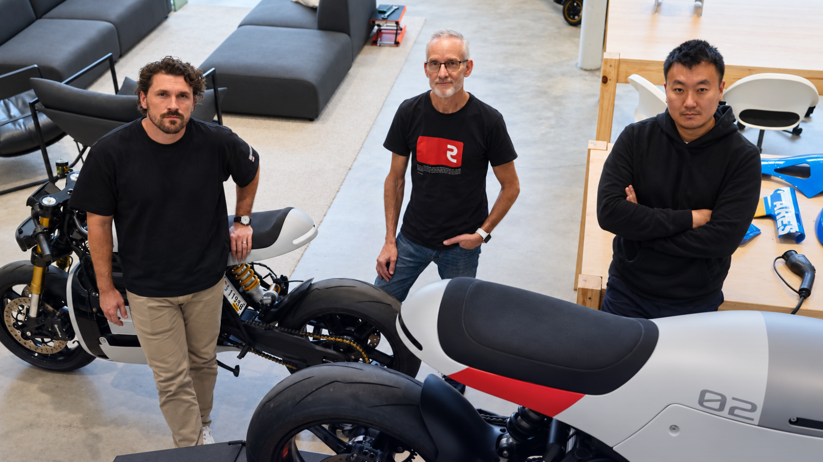 Three members of the Real Motors team alongside Project ARES motorcycles.