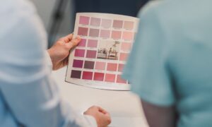 Professional painter holding color swatches while consulting with homeowner about interior paint choices