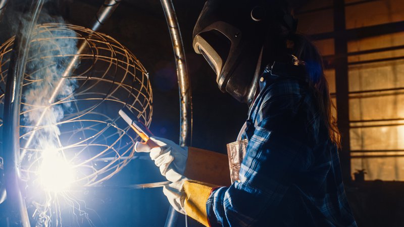 Welder fabricating a metal wireframe sphere
