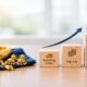Gold jewelry beside wooden blocks showing existing loan top-up with upward arrow
