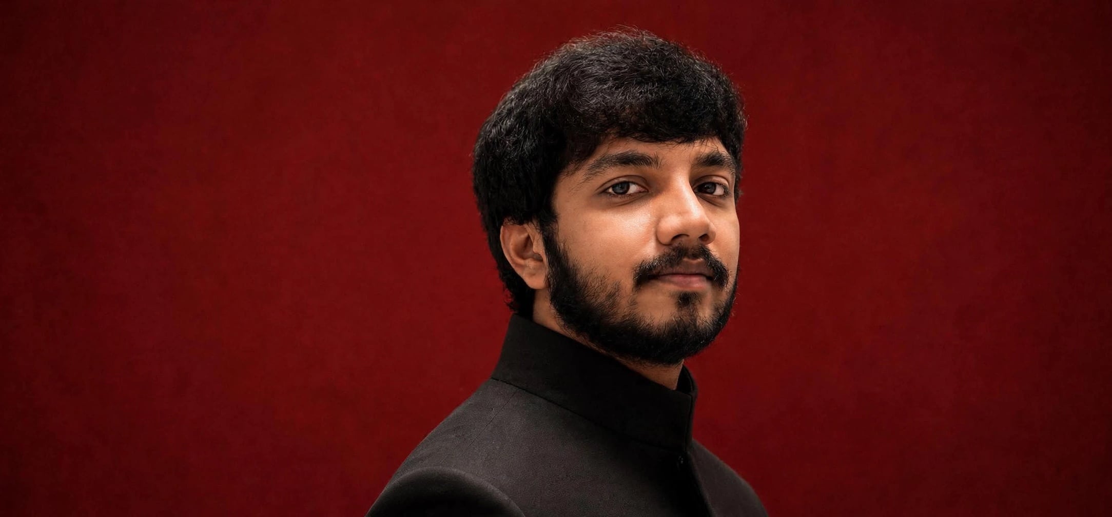 Rekapalli Ome Sai Vijay portrait against red background