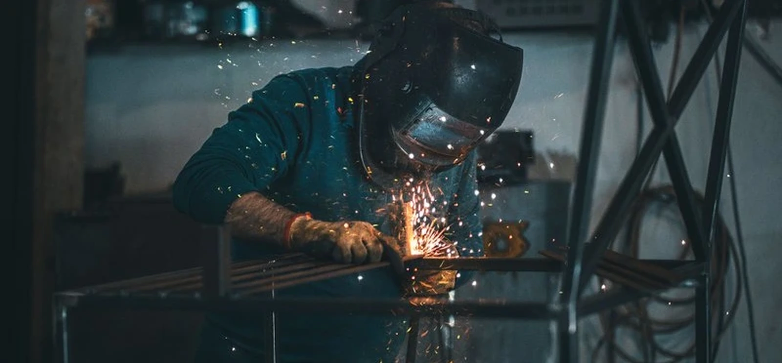 Welder creating sparks while building a welding portfolio piece